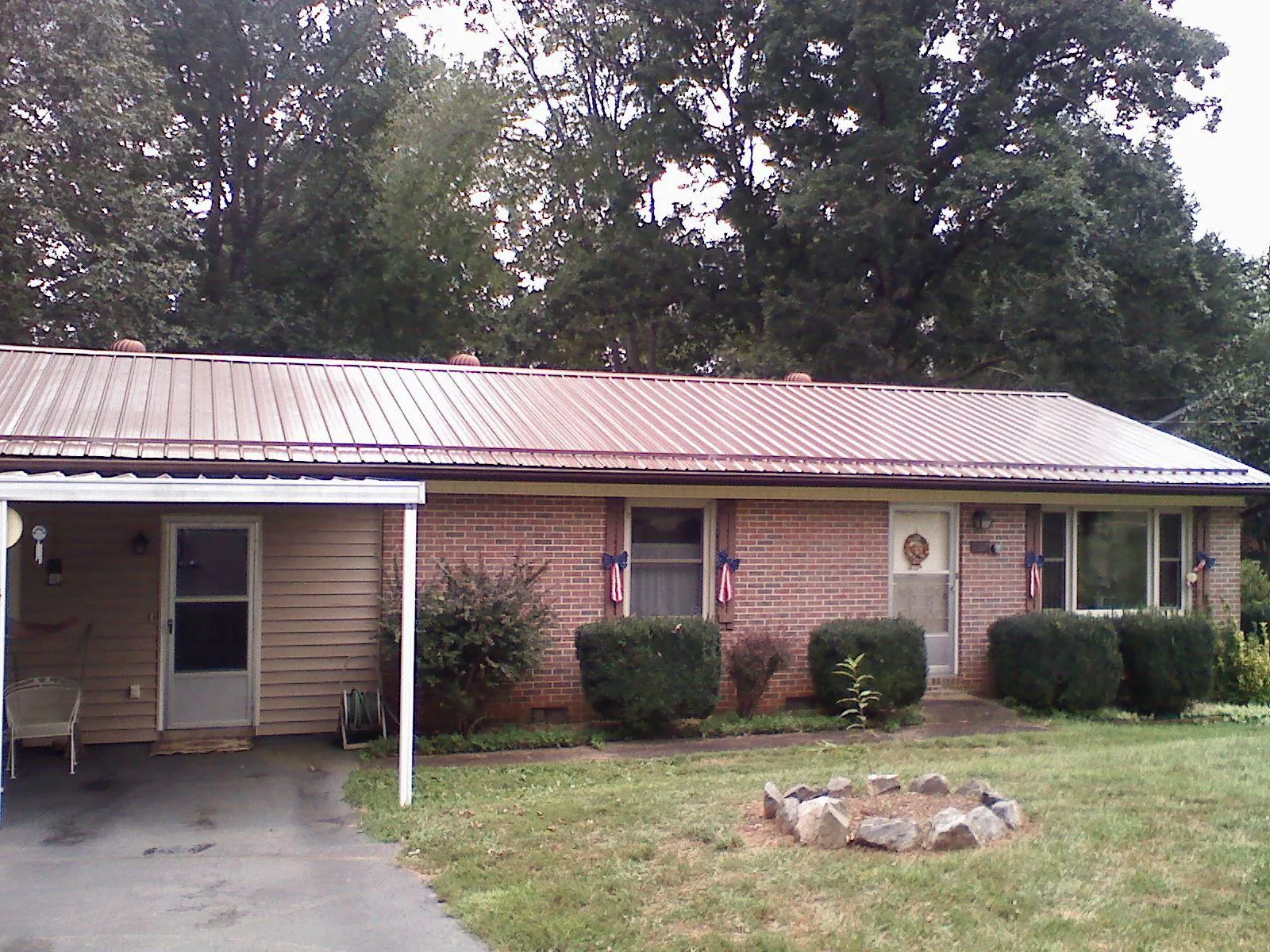 Bronze metal roof and carport on a brick ranch home — Roof Repair work by our crew in Gold Creek